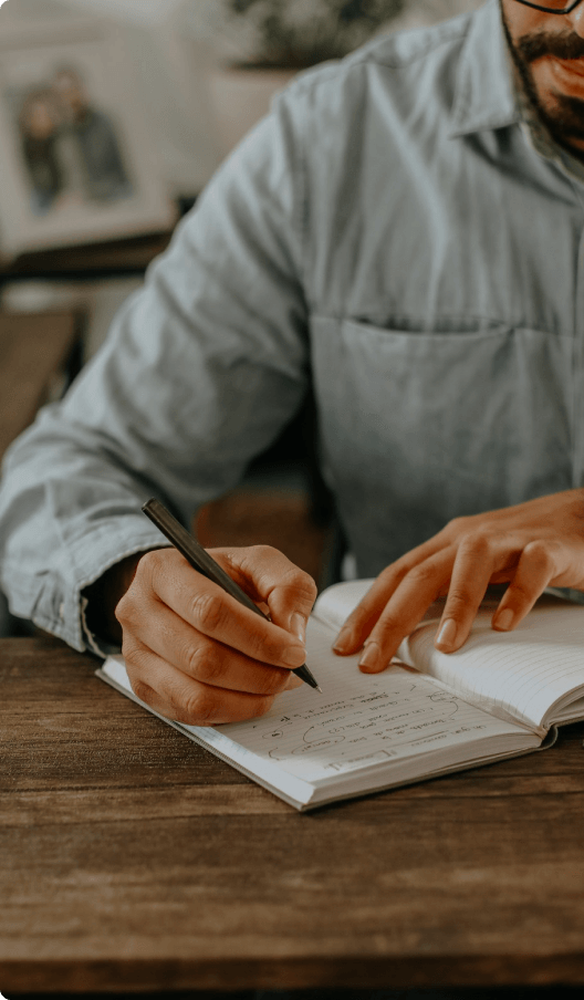 man writing in notebook