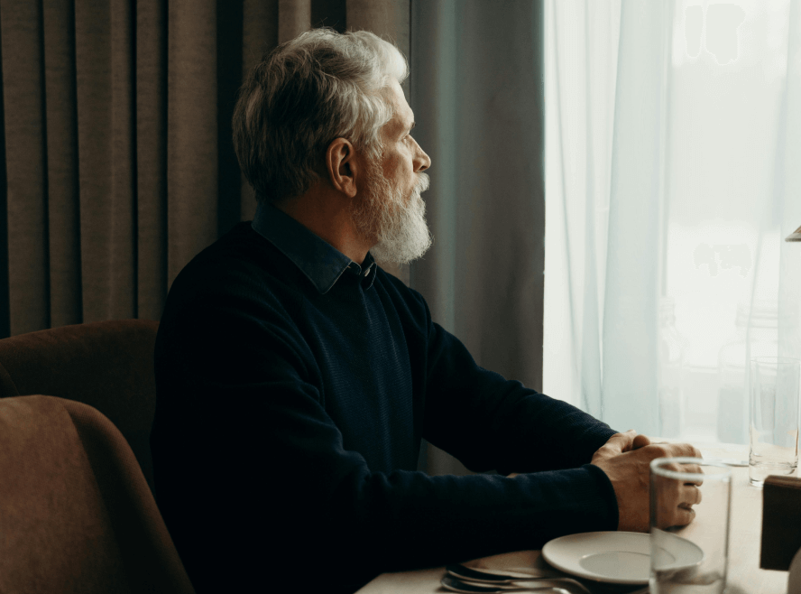 older man looking out window