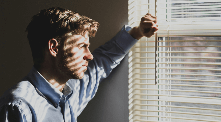 man looking out window